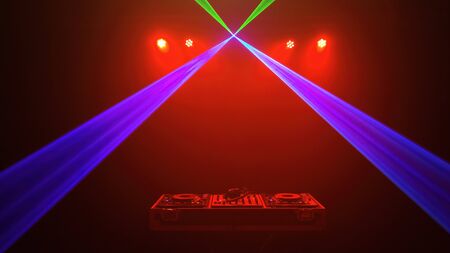 DJ - Disc jockey mixer and headphones. Disco lights and laser. Red, green and blue environmentの写真素材