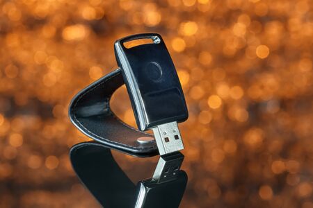 Metal USB flash drive on orange background with out-of-focus. Close-up
