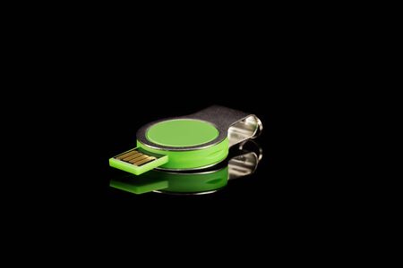 Green USB flash drive on black isolated background. Close-up