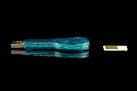 Blue flash drive with USB SIM card reader on black insulated background. Close-upの写真素材