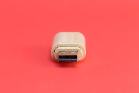 Wooden USB stick on red background. Close-up