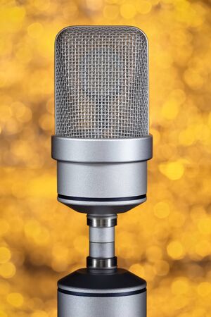 Mic - Close-up of a professional large-diaphragm condenser microphone. Orange background with blurred linesの写真素材