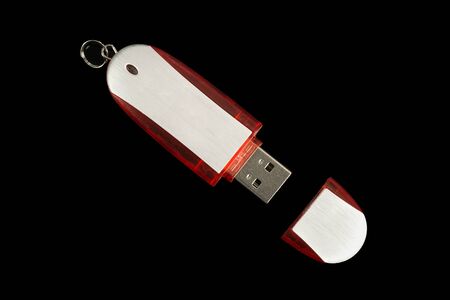USB Memory Stick - Metal and red flash drive on an isolated black background. Viewed from close upの写真素材