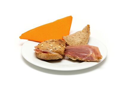 Serrano ham sandwich on a plate with an orange napkin. isolated white backgroundの写真素材