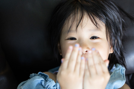 portrait of smiley eyes of asian little girl showing innocent and playful emotionの写真素材