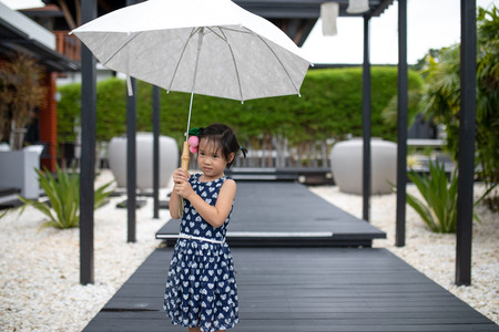 Asian cute girl wearing blue clothes and posing with umbrellaの写真素材