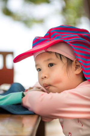 Lethargic Asian child in pink swimwear looks sleepyの写真素材