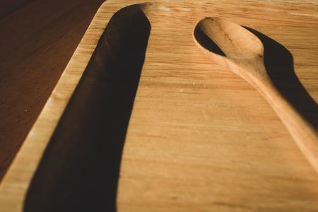 Wooden tea spoon on wooden tray with natural light fron windowの写真素材