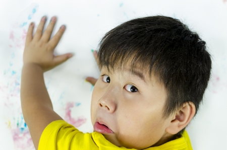 a child being caught while painting on the wallの写真素材