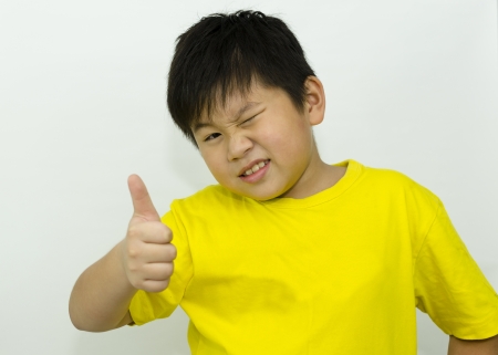 a chinese boy with his thumb up over white backgroundの写真素材