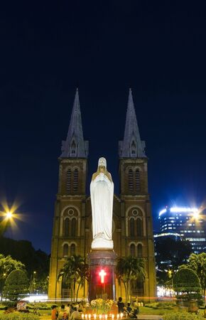 night view of notre dame of Saigon city with people praying by the statueのeditorial素材