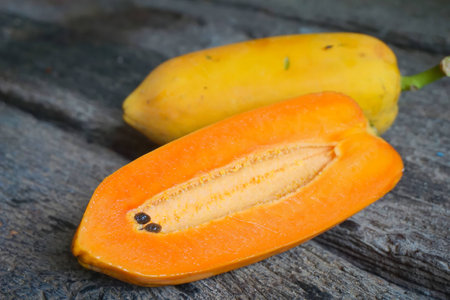 Papaya fruits are placed on the floor plates, old wood.の写真素材