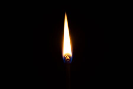 Safety match burns in front of isolated dark black backgroundの写真素材