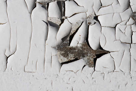 White cracked texture. Damaged, aged and weathered surface. Old painted wall with crack.の写真素材