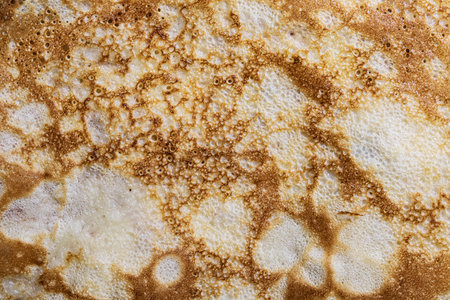 Pancake surface texture and pattern. Close-up of thin hot pancakes in a plate. Traditional rustic food. Graphic resource. Table top view.の写真素材