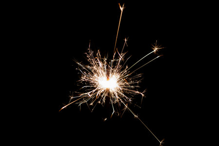 Burning sparkler isolated on black background. Fireworks theme. Light effect and texture. Christmas and new year decoration.の写真素材