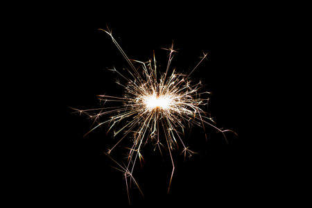 Burning sparkler isolated on black background. Fireworks theme. Light effect and texture. Christmas and new year decoration.の写真素材
