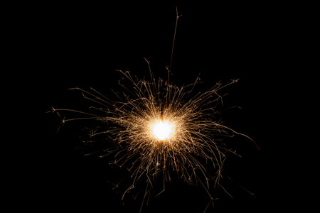Burning sparkler isolated on black background. Fireworks theme. Light effect and texture. Christmas and new year decoration.の写真素材