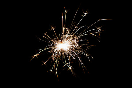 Burning sparkler isolated on black background. Fireworks theme. Light effect and texture. Christmas and new year decoration.の写真素材