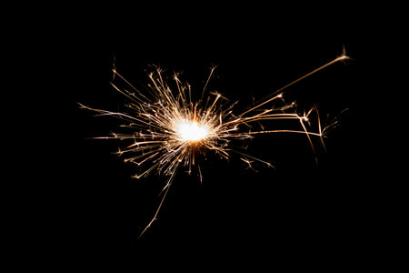 Burning sparkler isolated on black background. Fireworks theme. Light effect and texture. Christmas and new year decoration.の写真素材