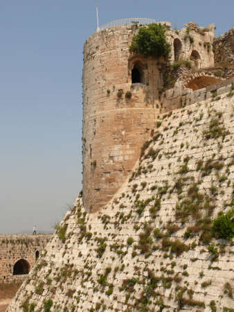 Man under citadel tower, fortification castle walls, Krak des Chevaliers, crusaders fortress, Syriaの写真素材