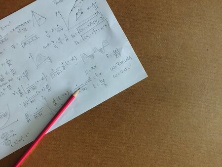The mathematical equations on a sheet of paper on the desk