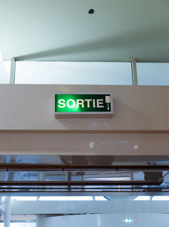 French exit "Exit" light panel with direction indicatorのeditorial素材