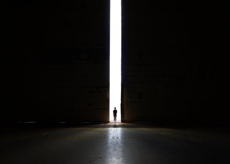 gate of hope and light, exit out of the darkness, silhouette walking into freedomの写真素材