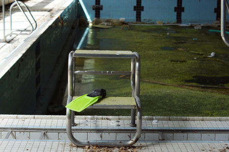 closed abandoned swimming pool, dirty water full of algae