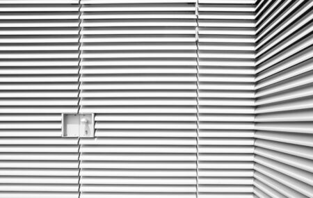 Locked up, louvered steel forms industrial art, punctuated by an embedded lockの写真素材
