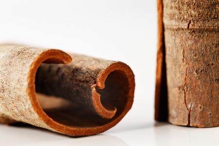Whole cinnamon sticks shot in a creative abstract manner against a white background