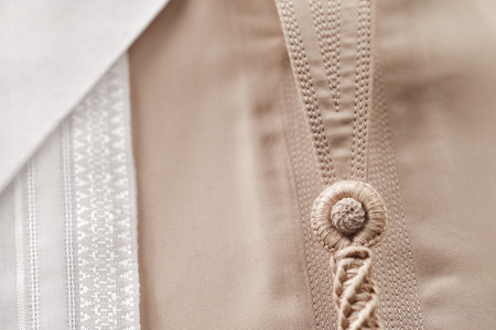 A white Ghutrah is photographed here with a fawn colored Kandura, which form the basis of traditional Arab clothing for menの写真素材