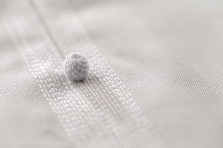 An abstract close up image of the fine detailed stitching seen in the Kandura, the ankle-length...