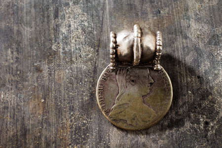 Traditional silver jewelry from the southern Arabian Peninsula shot on a textured wooden tableの写真素材