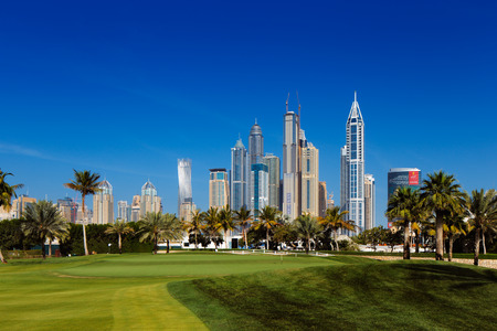Dubai, UAE  A cityscape view of Dubai Marina from a nearby lush green golf courseのeditorial素材