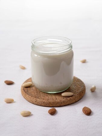 Close up of a glass of almond milk on light background, substitute milk for vegan or lactose intolerantの写真素材