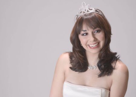 Bright and bubbly young woman just crowned prom or beauty queen, wearing a sparkling tiaraの写真素材