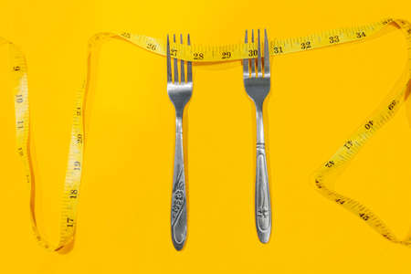 Showing excess weight gain around the waist with a tailor's tape measure.の写真素材