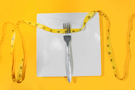 Showing excess weight gain around the waist with a tailor's tape measure.の写真素材