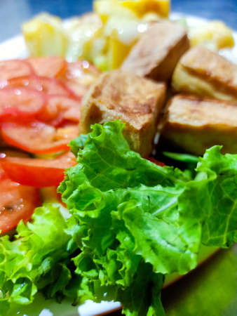 Fusion cuisine, Asian tofu with European salad and fried potatoes.