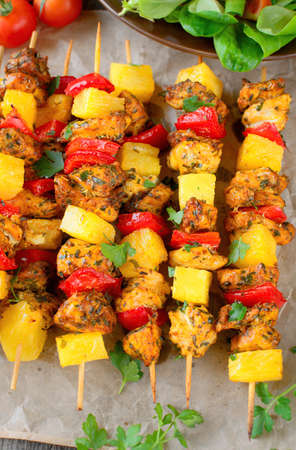 Sweet and spicy skewers with chicken, pepper, pineapple, garnished with parsley leaves. Gourmet meal.の写真素材