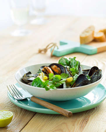 Stewed mussels with asparagus served with yoghurt sauce. Served in a rustic style restaurant. Delicious gourmet dish.の写真素材