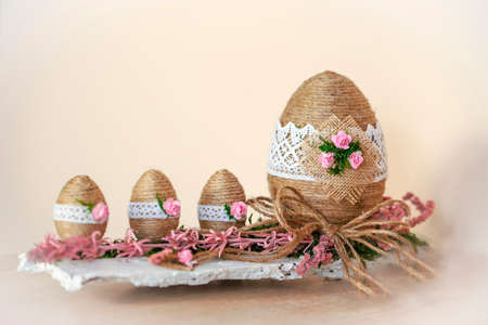 Easter decoration - eggs in baskets made of hemp twine, decorated with beautiful flowers and...