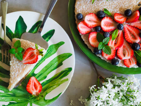 No-bake tart of tapioca and coconut milk covered with fresh fruit. The composition is decorated with...