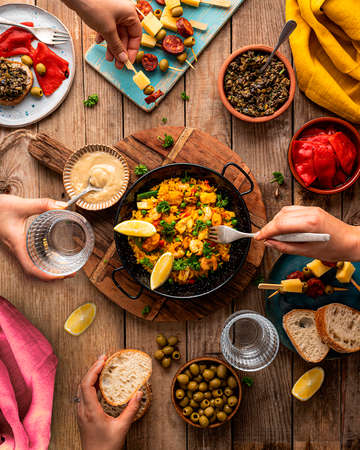 PAELLA with shrimps additionally served with bruschetta and Italian antipasto skewers with sausage. Spanish and Italian cuisine. Paella is a Spanish rice dish originally from Valencia.の写真素材