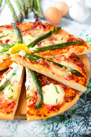 Pizza with asparagus, bacon and fried egg. Italian cuisine. Culinary concept. Gourmet meal.の写真素材