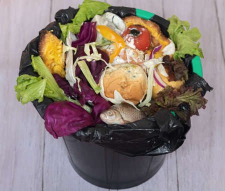 Waste bin with unused food. Food waste as a global problem in the world. Close-up. Concept of wasting and discarding unused food. Top view.の写真素材