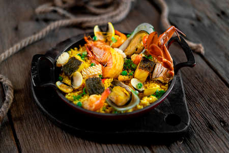 Steamed and grilled seafood served with rice in curry sauce. Close up. Rustic style. Culinary concept.の写真素材