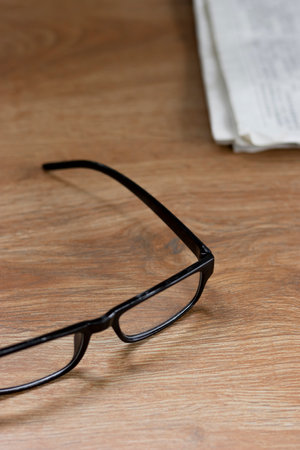 Reading glasses as a symbol of the aging human body. The concept of visual impairment - myopia and farsightedness. Close-up. Isolated on a brown background. Interior.の写真素材
