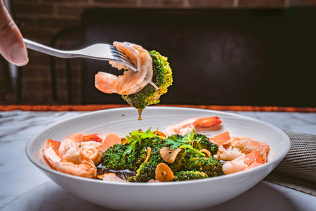 Shrimp and broccoli salad. Grilled shrimp on a fork over a full plate of salad with grilled shrimp and steamed broccoli. Macro. Close-up. Italian cuisine. Isolated on a white backgの写真素材